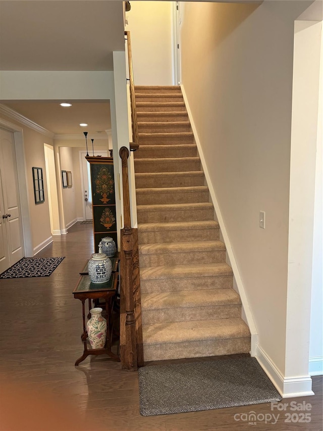 stairs with wood finished floors, baseboards, crown molding, and recessed lighting