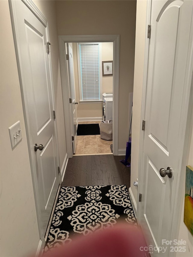 hallway with dark wood-style flooring and baseboards