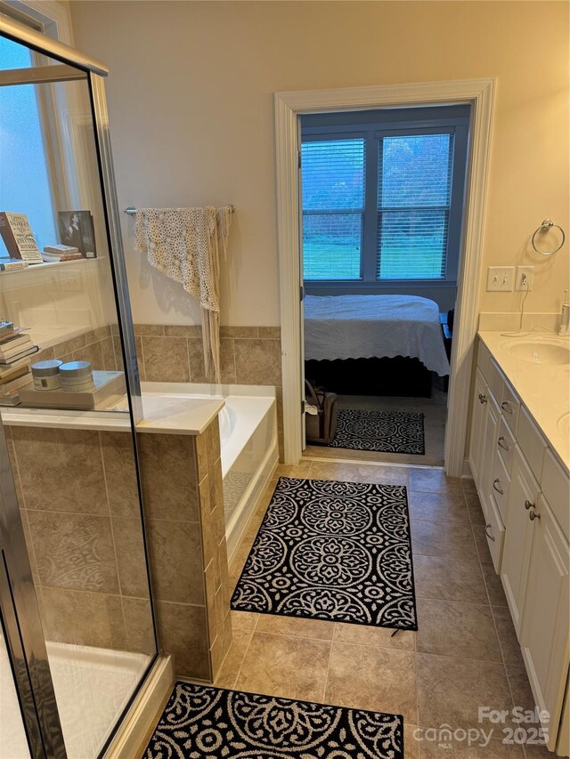 full bath with a shower stall, vanity, a garden tub, ensuite bath, and tile patterned flooring
