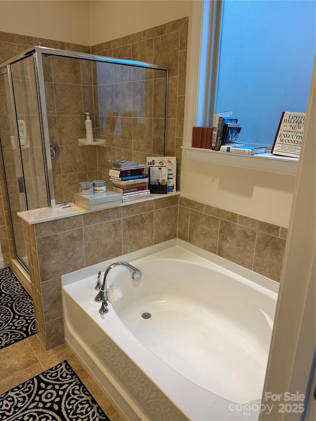 full bathroom featuring a stall shower, a bath, and tile patterned floors