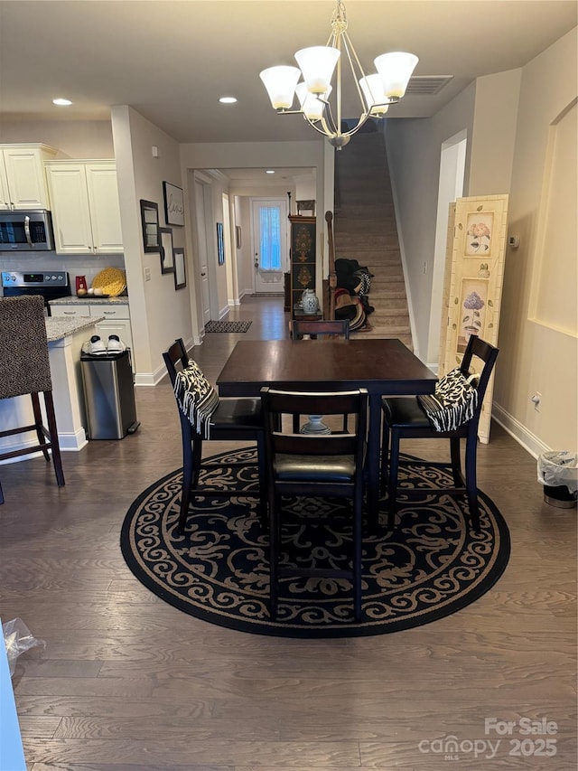 dining area featuring dark wood finished floors, a chandelier, baseboards, and recessed lighting
