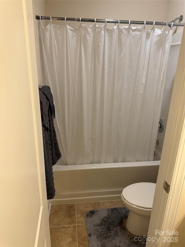 full bath with shower / bath combo, tile patterned floors, and toilet