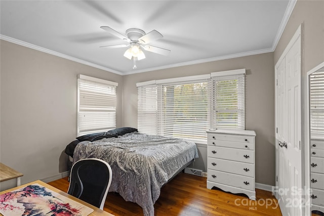 bedroom featuring dark wood-type flooring, ceiling fan, a closet, and crown molding