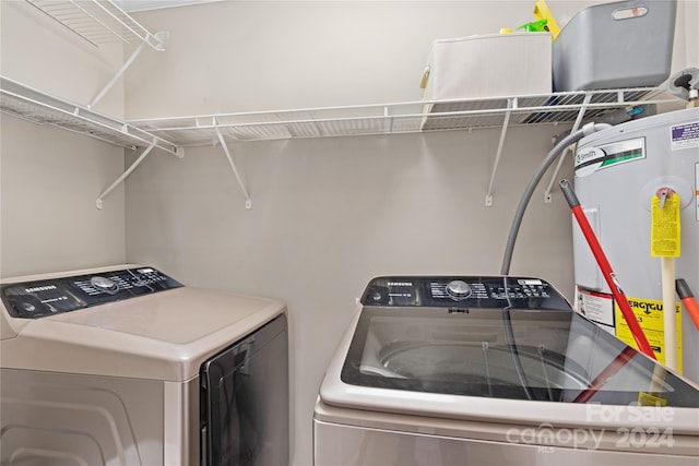 clothes washing area with gas water heater and independent washer and dryer