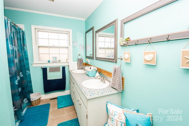 bathroom featuring vanity, tile patterned flooring, crown molding, and plenty of natural light