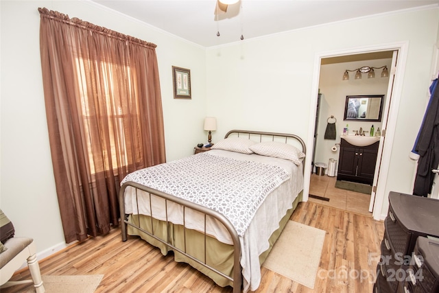 bedroom featuring ornamental molding, light hardwood / wood-style floors, ceiling fan, and connected bathroom