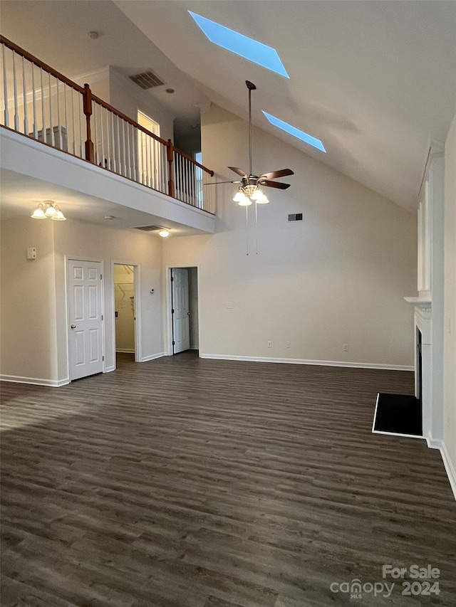 unfurnished living room with a skylight, ceiling fan, high vaulted ceiling, and dark hardwood / wood-style flooring