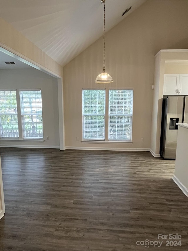 unfurnished dining area featuring a wealth of natural light, high vaulted ceiling, and dark hardwood / wood-style flooring