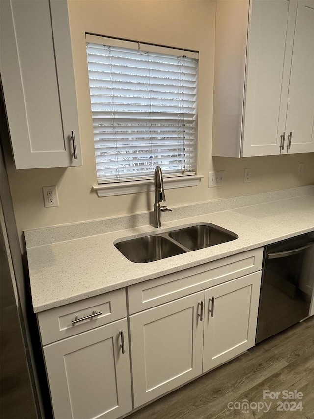 kitchen featuring white cabinets, sink, stainless steel dishwasher, and dark hardwood / wood-style flooring