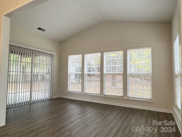 unfurnished room with a wealth of natural light, lofted ceiling, and dark wood-type flooring