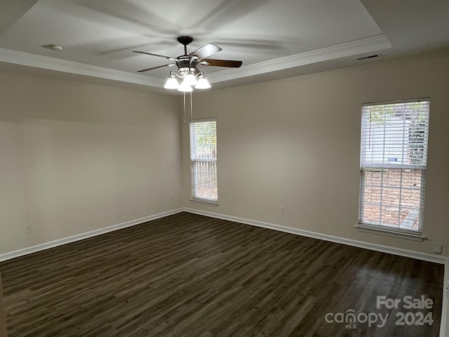 empty room with dark wood-type flooring, crown molding, and plenty of natural light