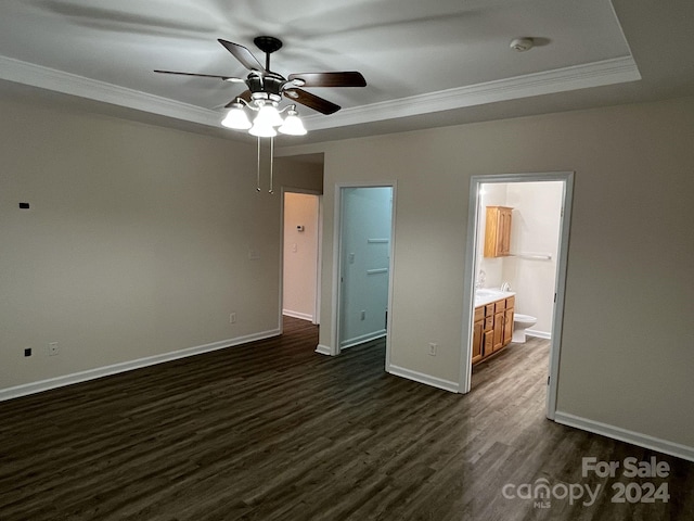 unfurnished bedroom with ceiling fan, dark hardwood / wood-style floors, ornamental molding, and ensuite bath