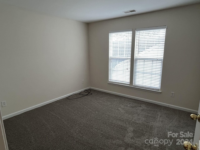 empty room featuring dark colored carpet