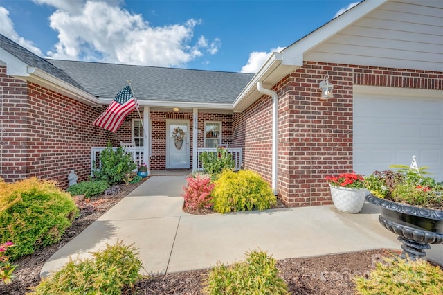 property entrance featuring covered porch and a garage