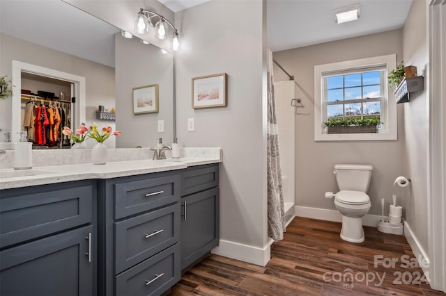 full bathroom with toilet, hardwood / wood-style floors, shower / bath combo with shower curtain, and vanity