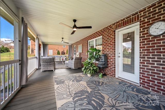 wooden deck with covered porch, outdoor lounge area, and ceiling fan