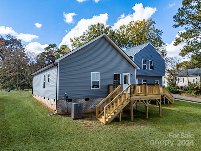 back of property featuring central air condition unit, a deck, and a lawn