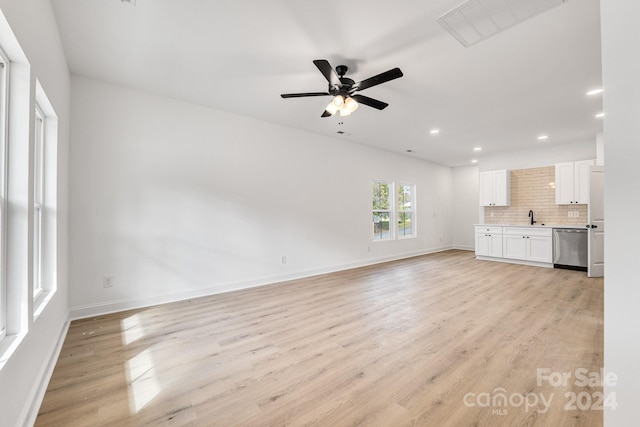 unfurnished living room with a sink, recessed lighting, light wood-type flooring, a ceiling fan, and baseboards