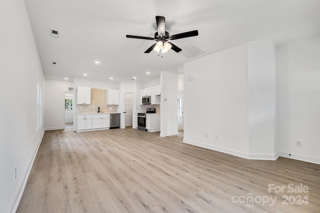 unfurnished living room featuring a ceiling fan, light wood-style flooring, recessed lighting, baseboards, and a sink