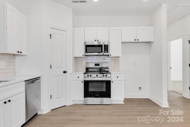 kitchen featuring appliances with stainless steel finishes, light wood-type flooring, white cabinetry, light countertops, and recessed lighting