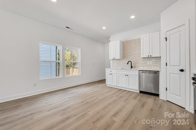 kitchen featuring white cabinetry, light hardwood / wood-style floors, tasteful backsplash, and stainless steel dishwasher