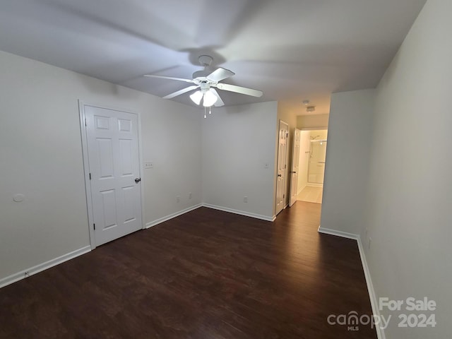 empty room featuring ceiling fan and dark hardwood / wood-style flooring