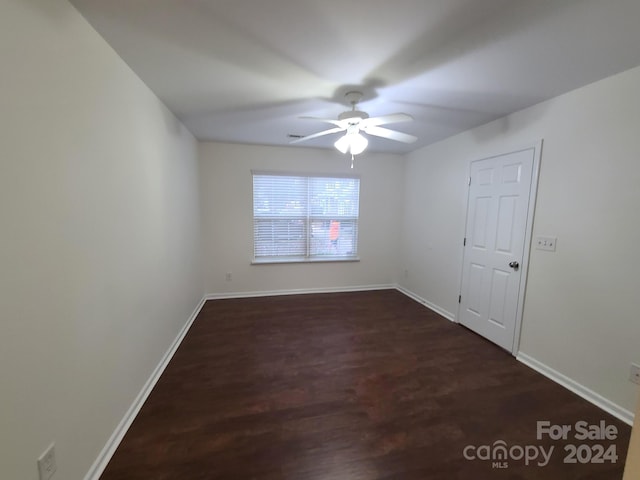 empty room featuring ceiling fan and dark hardwood / wood-style flooring