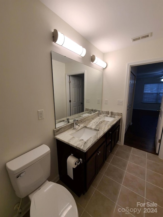 bathroom featuring toilet, vanity, and tile patterned flooring