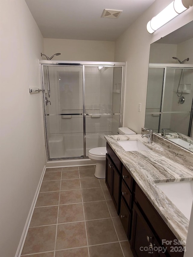 bathroom with vanity, toilet, tile patterned floors, and an enclosed shower