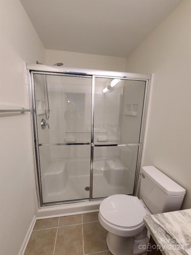 bathroom with vanity, toilet, walk in shower, and tile patterned flooring