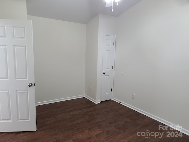 spare room featuring dark wood-type flooring and ceiling fan