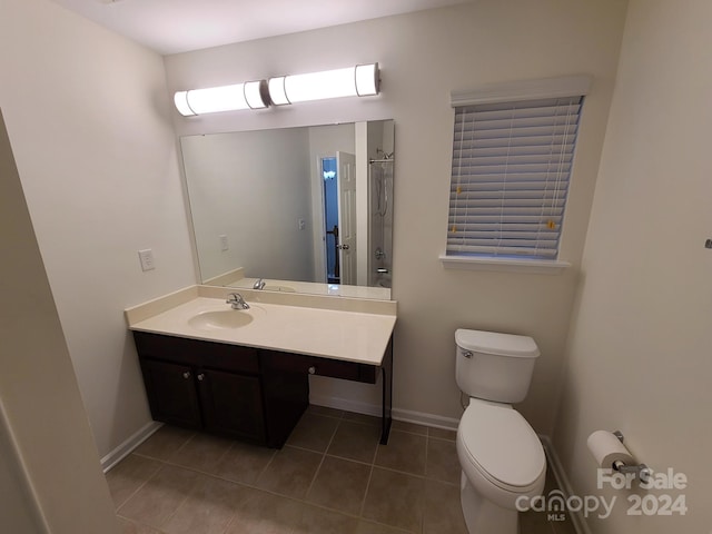 bathroom with toilet, vanity, and tile patterned floors