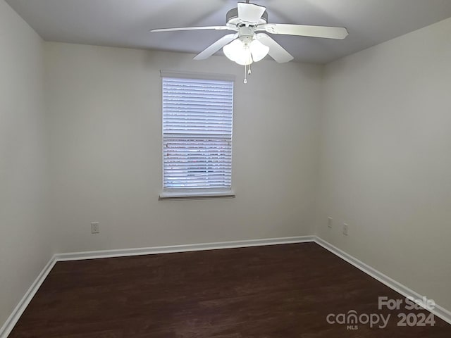 spare room with dark wood-type flooring and ceiling fan