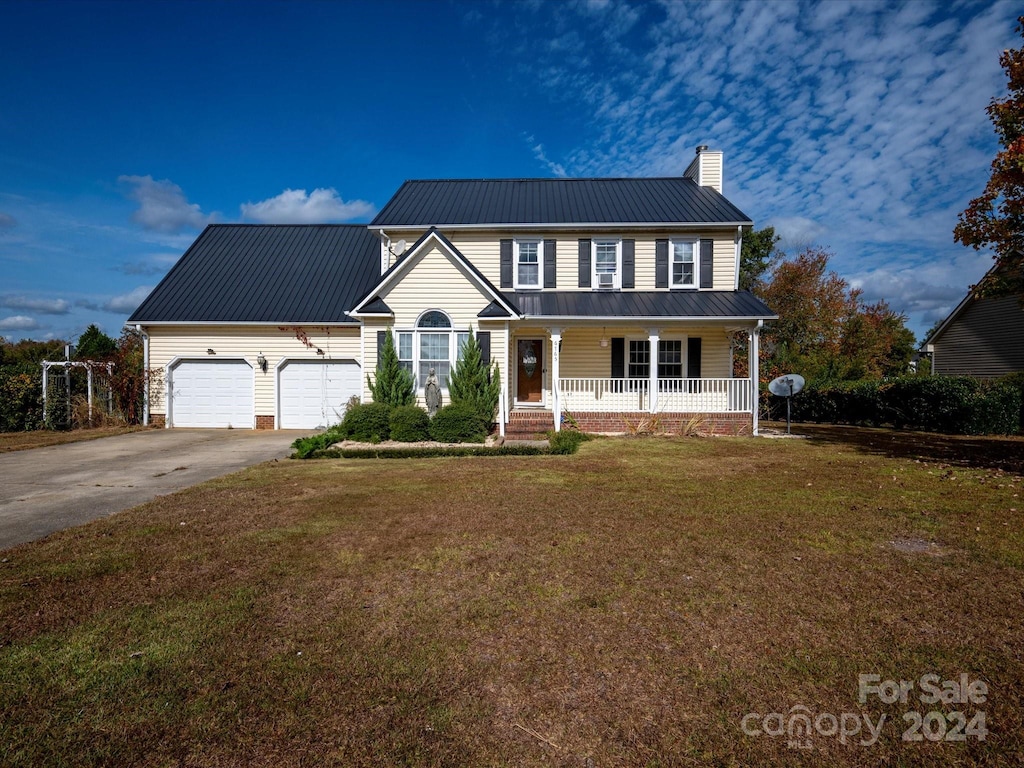 view of front of home featuring a front lawn, a garage, and covered porch