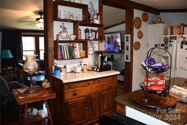 kitchen featuring ceiling fan, white fridge, light stone counters, and lofted ceiling