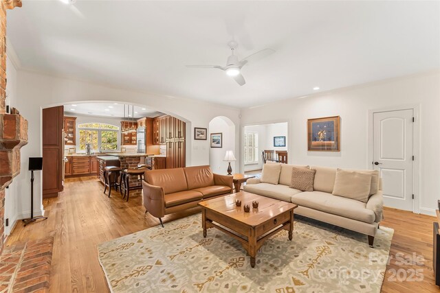 living room with light wood-type flooring and ceiling fan