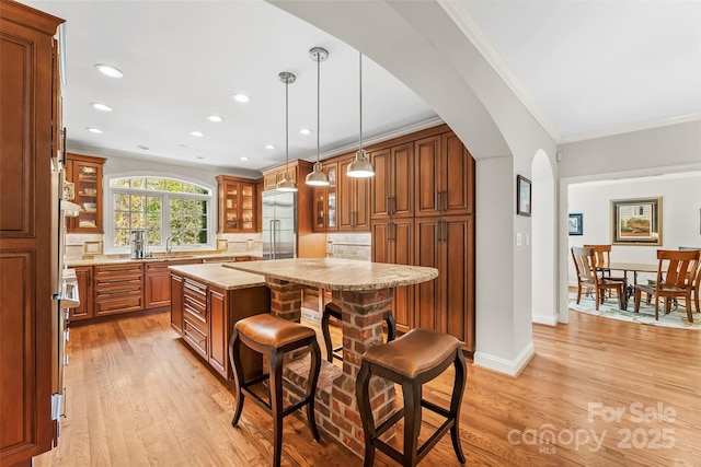 kitchen featuring a center island, hanging light fixtures, crown molding, and decorative backsplash