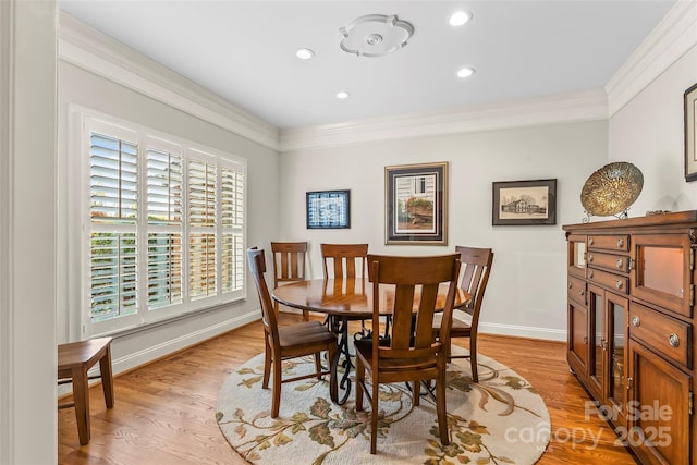 dining area with crown molding and light wood-type flooring