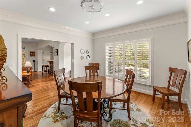 dining room featuring crown molding and light hardwood / wood-style floors