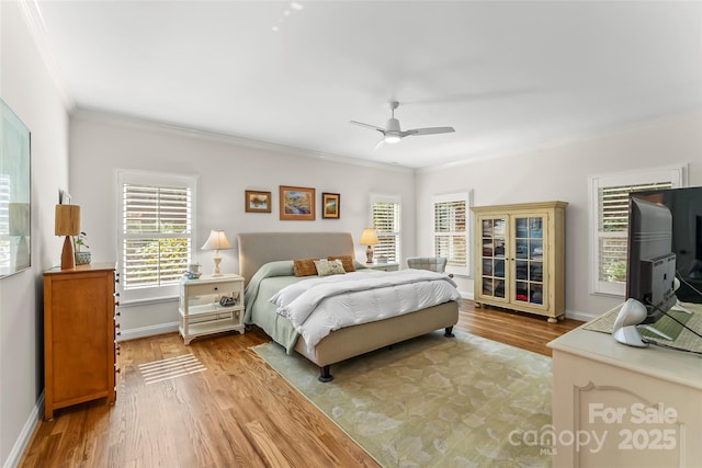 bedroom featuring ceiling fan, light hardwood / wood-style floors, and crown molding