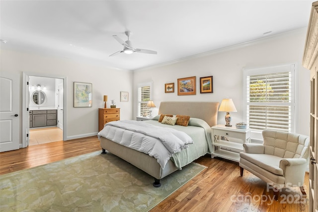 bedroom with ceiling fan, crown molding, light hardwood / wood-style flooring, and ensuite bath