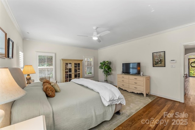 bedroom featuring light wood-type flooring, ceiling fan, and crown molding