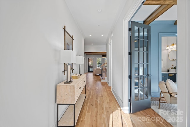 corridor featuring ornamental molding and light hardwood / wood-style floors