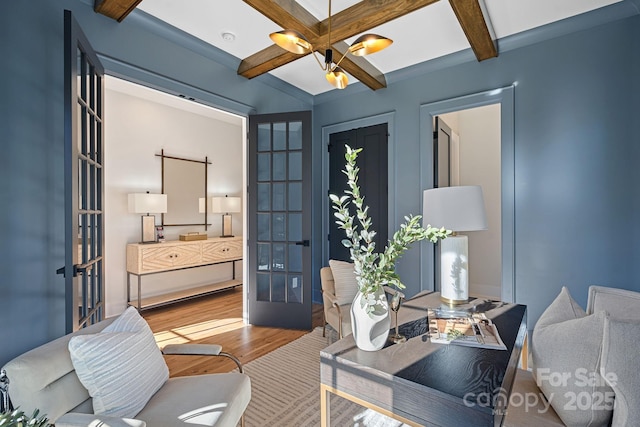 office area with wood-type flooring, beamed ceiling, an inviting chandelier, coffered ceiling, and french doors