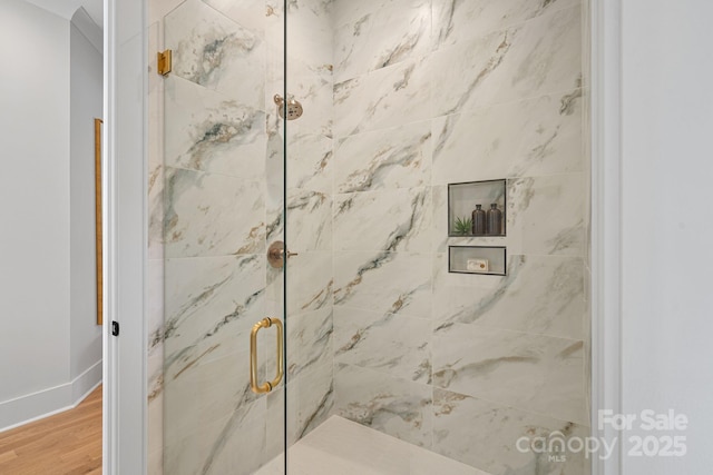 bathroom with hardwood / wood-style flooring and an enclosed shower