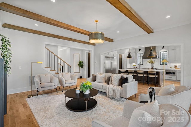 living room featuring beam ceiling and light hardwood / wood-style flooring