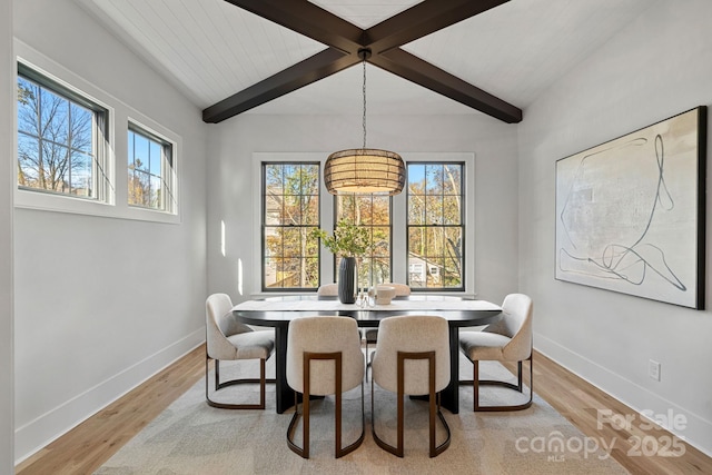 dining room with beam ceiling, wood ceiling, and light hardwood / wood-style flooring