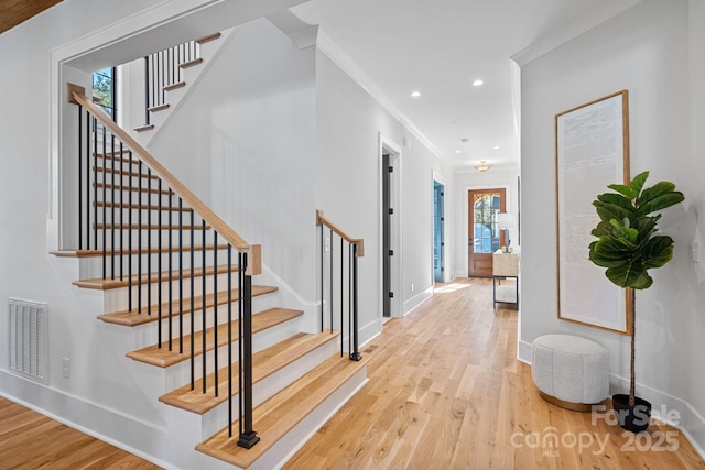 interior space with wood-type flooring and crown molding