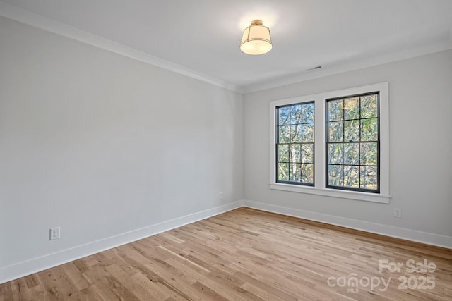 empty room with light wood-type flooring and ornamental molding