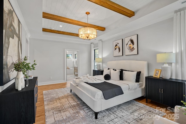 bedroom featuring ensuite bath, wood-type flooring, wood ceiling, and a notable chandelier